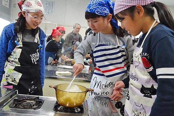 有機栽培米を使った炊飯実習をする小学生たちの画像