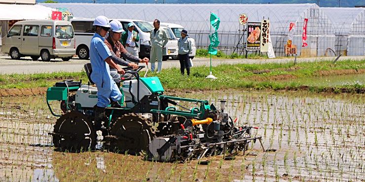有機農業オープンフィールドで乗用除草機の実演をする様子